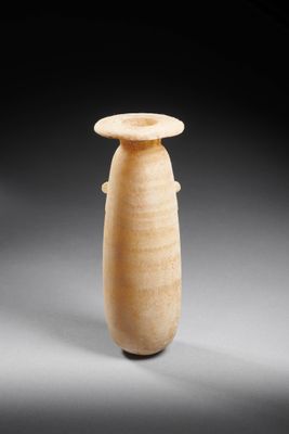 un vieux vase posé sur une table, sur une surface grise
