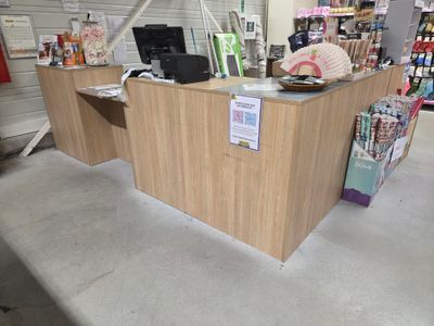 une photo d'un magasin avec un comptoir au milieu de la pièce