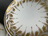 a white and gold plate with a gold leaf design on it