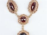 un collier en or orné d'une pierre noire et d'une chaîne en or