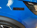 a close up of a blue car with a sticker on it