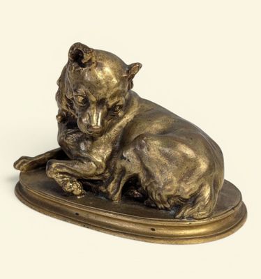 statue en bronze représentant un chien couché sur un plateau, sur fond blanc