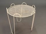 an image of a white metal table with a basket on top
