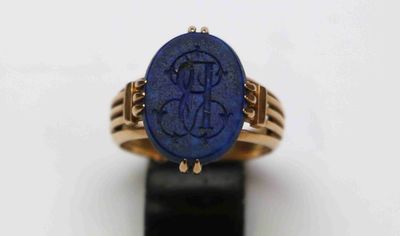 Gros plan sur une bague en or ornée d'une pierre bleue