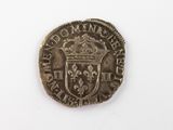 une pièce d'argent surmontée d'une couronne