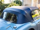 a blue car with a black top parked on the street