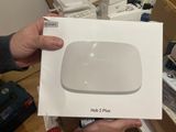 someone holding a box with a white apple tv sitting on top of it