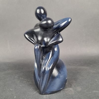 statue d'une femme tenant une fleur dans sa main droite