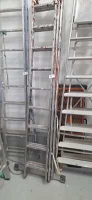 many ladders in a room with a lot of stuff on the floor