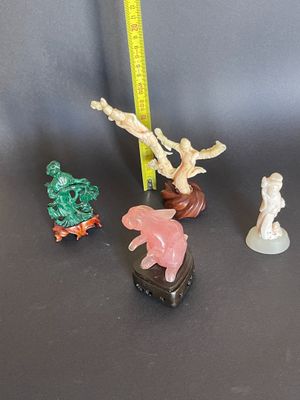 Plusieurs figurines de formes et de tailles variées sont posées sur une table