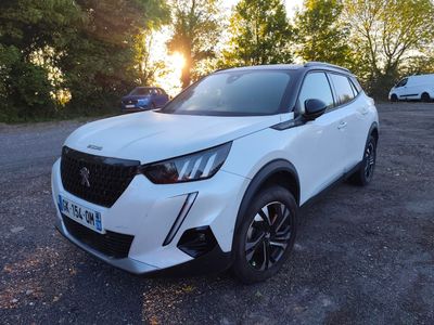 un SUV blanc garé sur un parking, avec des arbres en arrière-plan