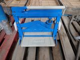 une paire de ciseaux bleus posée sur une palette dans un entrepôt