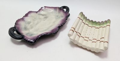 two pieces of pottery sitting on top of a table next to each other