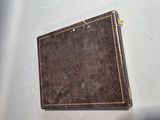 a small brown book sitting on a white surface
