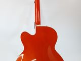 an orange guitar sitting on top of a stand against a white background