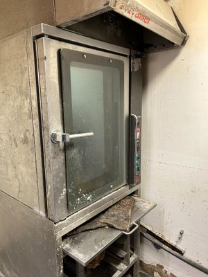 a small oven that is sitting in the corner of a room