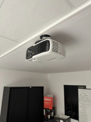 un projecteur fixé au plafond au-dessus d'un bureau d'ordinateur