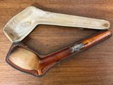 une pipe en bois et un étui en cuir posés sur une table