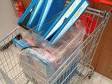 a shopping cart full of books and folders in it