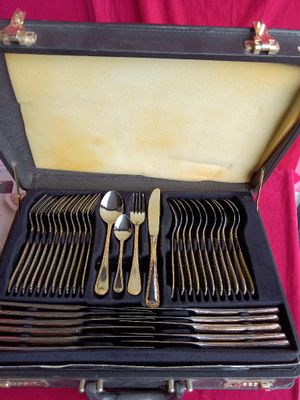 silverware in a case on a table with a pink table cloth