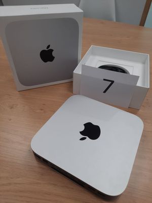 une caisse de pommes posée sur une table en bois, à côté d'un ordinateur Apple