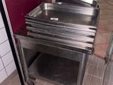 a stainless steel sink in the middle of a tiled floor
