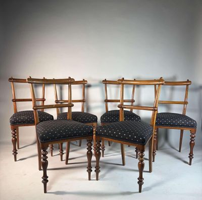 quatre chaises en bois, dotées de coussins rembourrés, sont disposées en rangée