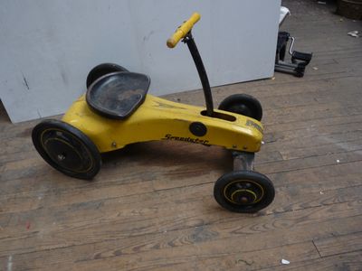 une petite voiture jaune posée sur un parquet