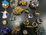 a lot of rings and brooches on a table
