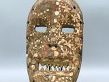 gros plan d'un masque en bois sur une surface blanche