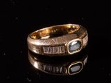 gros plan d'une bague en or sur une surface noire