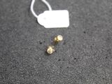 a small piece of jewelry on the ground next to a tag