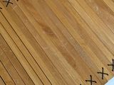 a close up of a piece of wood with black stitching on it