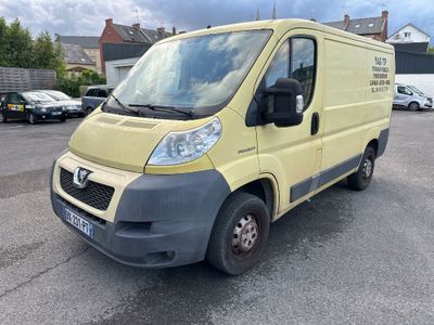 La camionnette jaune est garée sur le parking, à côté d'autres voitures.