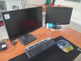 a computer desk with two monitors and a keyboard