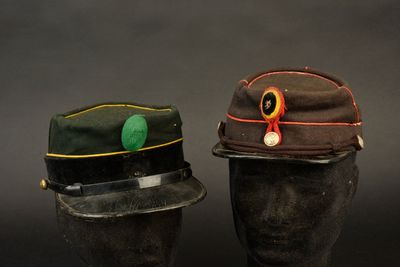 une paire de chapeaux posés sur des têtes de mannequins, sur fond noir