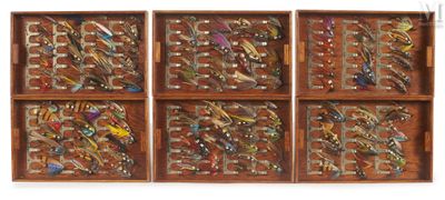 quatre boîtes en bois remplies de leurres de pêche variés, posées sur une surface blanche