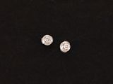 a pair of silver earrings on a black surface