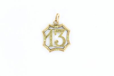 un pendentif en or sur lequel est gravé le chiffre treize