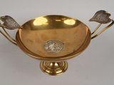 an image of a gold bowl with two birds on it