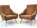 pair of mid century style lounge chairs with upholstered cushions