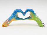 two hands making a heart shape with paint splatters on them