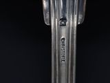 close up of a silver spoon with a black background