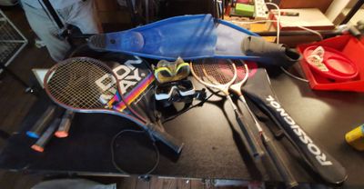 de nombreuses raquettes de tennis et d'autres équipements sportifs posés sur la table