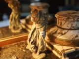 a small statue of a woman standing next to a mirror