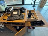 a desk with a laptop, keyboard, mouse, and other items on it