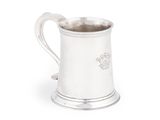 une chope ancienne en argent avec une anse, sur fond blanc