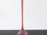 pink glass vase on a black table against a white background