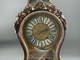 a clock that has a bird on top of it