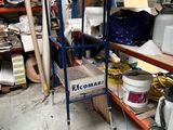 a blue cart in the middle of a room filled with items
